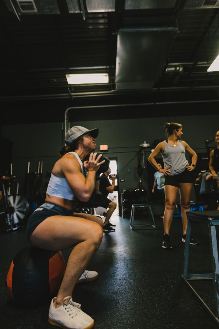 Coach spotting a member during a bench press set at TitanUp Jacksonville Beach