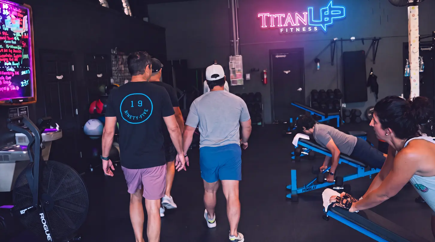 Members training beneath the neon TitanUp Fitness sign at Nocatee