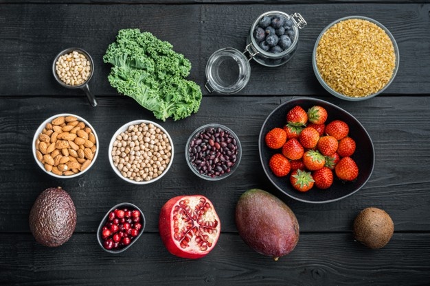 Whole foods flat lay with grains, greens, and fruit