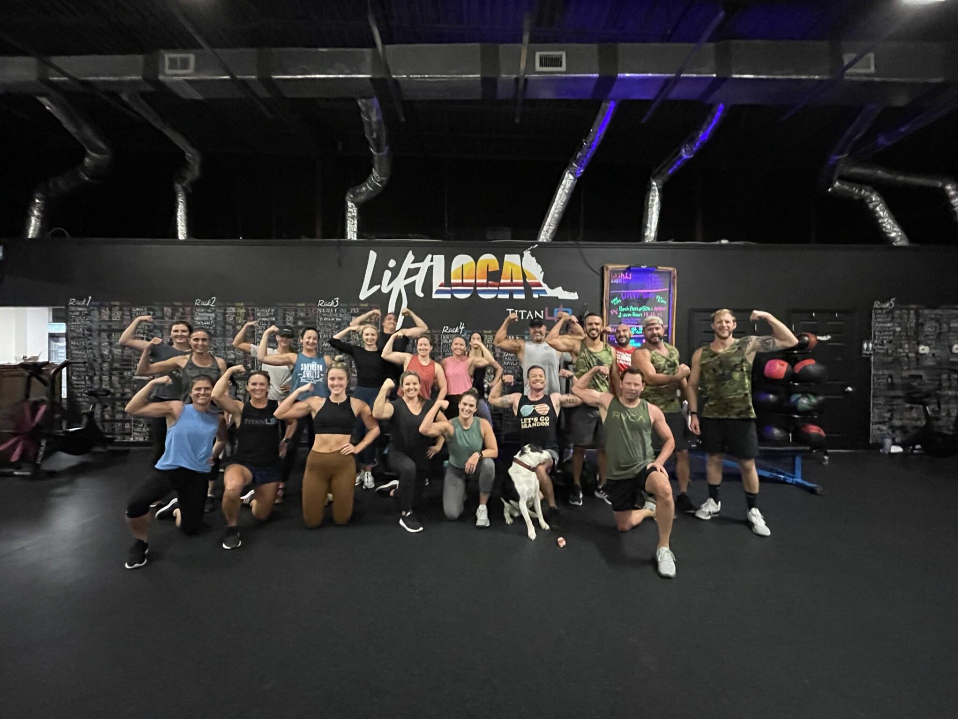 TitanUp members flexing under the Lift Local mural