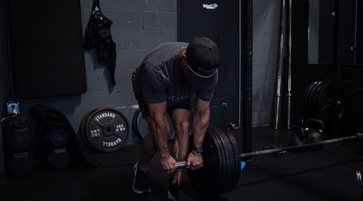 Member deadlifting a loaded barbell at TitanUp Jacksonville Beach