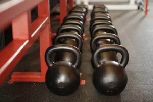 several black barbell cowbells on the floor for workout, exercise